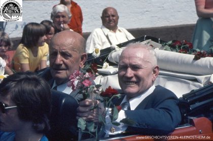 Das Foto stammt vom Festzug bei der 1000-Jahr-Feier der Gemeinde Kleinostheim im Jahre 1975. Zu sehen ist links Altbürgermeister Karl Wienand, rechts der Unternehmer Karl Wienand II.