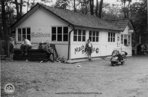 Das Foto zeigt die Gaststätte „Zur Waldschänke“ am Posten 28, vielen auch bekannt als „Waldheini“, benannt nach Heinrich Geißler, dem späteren Bürgermeister. Die Ausflugsgaststätte befand sich am früheren Bahnübergang in der Nähe des Haltepunktes „Rückersbacher Schlucht“.