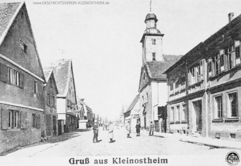 Die Ansichtskarte von 1920 zeigt einen Ausschnitt aus der Hauptstraße. Man sieht rechts die alte Schule, dahinter die Laurentiuskirche. Autos waren eher selten zu sehen.