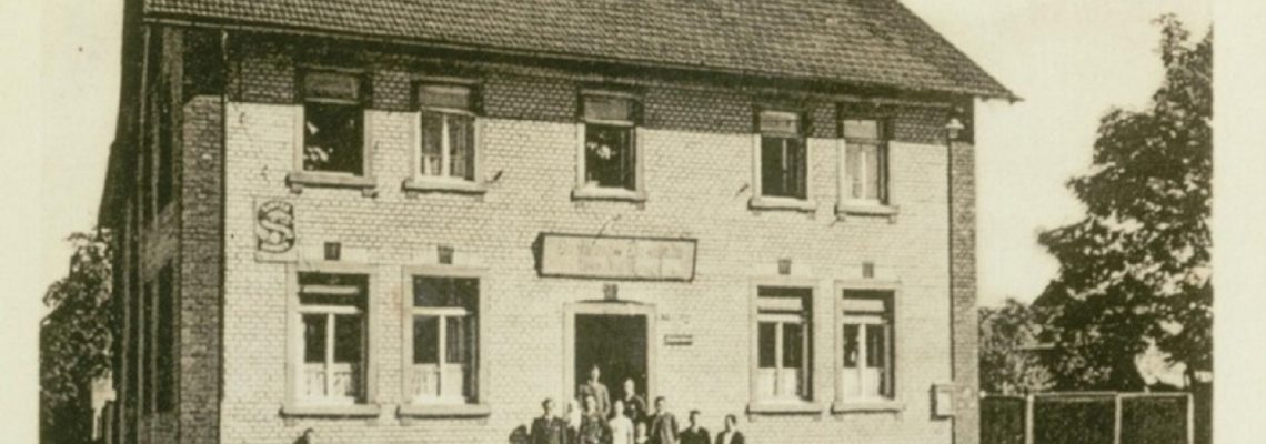 Das Foto aus dem Jahr 1940 zeigt das Gasthaus zur Eisenbahn, ab ca. 1968 auch bekannt unter dem Namen Cille-August. Gegründet wurde es 1906 von Cäcilie und Georg Wienand. Später bekam es den Namen „Kleinostheimer Hof“. 2020 wurde es geschlossen.