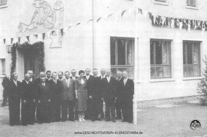 Das Foto von 1955 (?) zeigt die Geschäftsführung und die Verwaltungsmitglieder der Raiffeisenkasse vor dem ersten bankeigenen Verwaltungsgebäude in der Schillerstr.75. Leider sind uns nicht alle Personen auf dem Bild bekannt. Wenn Sie uns mit einem Teil der Namen helfen können, geben Sie uns bitte Bescheid.