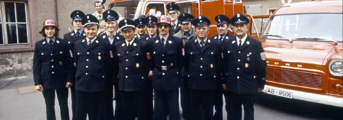 Das Foto zeigt die Feuerwehr in den 1970er Jahren im oben erwähnten Schulhof. Im Hintergrund sieht man das Sanitätsheim mit dem Roten Kreuz.Das Foto zeigt die Feuerwehr in den 1970er Jahren im oben erwähnten Schulhof. Im Hintergrund sieht man das Sanitätsheim mit dem Roten Kreuz.