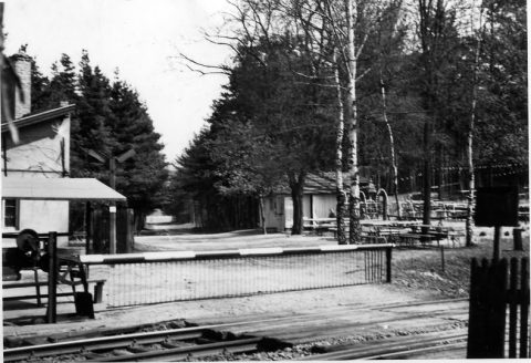 Das Foto zeigt den oben erwähnten Bahnübergang. Links sieht man das Gebäude des Postens 28, rechts befindet sich die Ausflugsgaststätte „Zum Waldheini“.