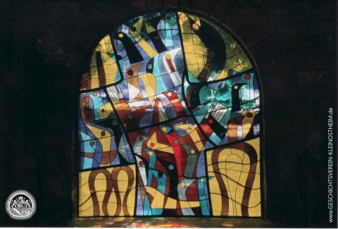 Dieses Bild ist auf dem Kleinostheimer Friedhof zu sehen. Der Entwurf stammt von dem französischen Künstler Raymond Mirande. Es ist eines von mehreren Bildern, die er für die 1994 renovierte alte Friedhofskapelle schuf. Es trägt den Titel „Franziskus predigt den Vögeln“. Die Bilder können in der alten Kapelle besichtigt werden.